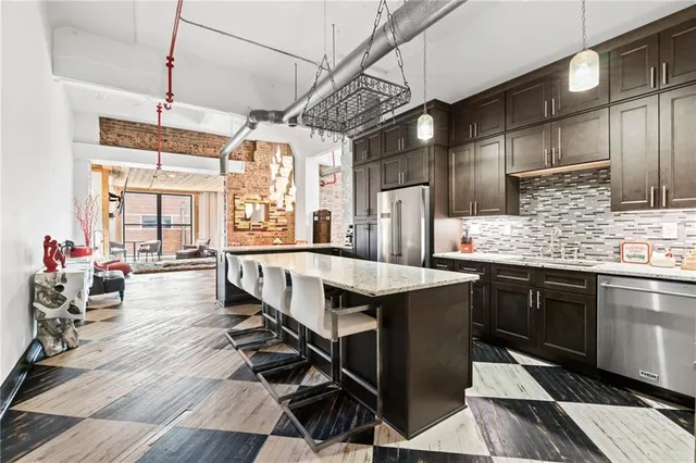 a kitchen with stainless steel appliances granite countertop a sink a stove and refrigerator