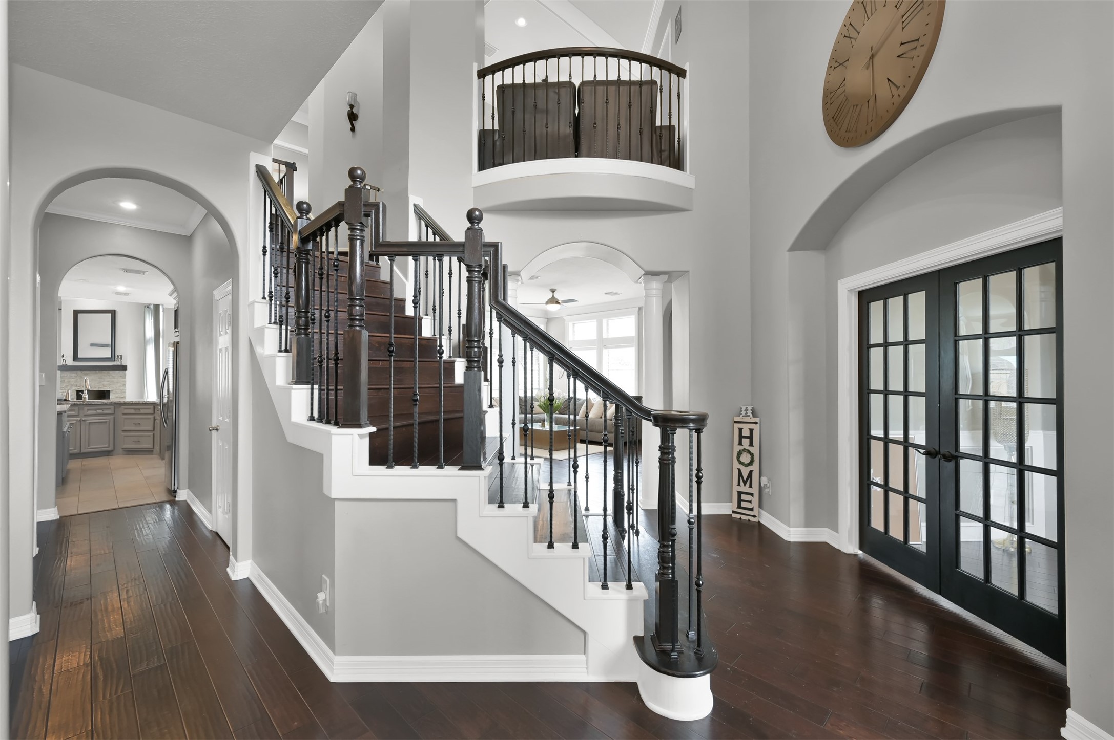 9706 Chipstead Court Spring, TX 77379 - Photo 4 of 44 Welcome home to a stunning entrance featuring a breathtaking wrought iron staircase. You can see a glimpse of your kitchen down the hallway to the left, your office on the right, and one of your formal living rooms in the background.