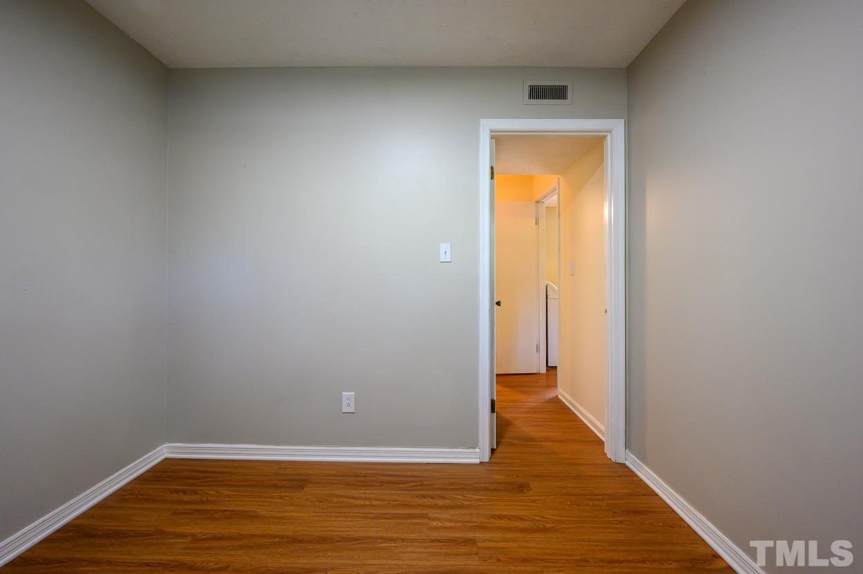 4208 Waterbury Road Raleigh, NC 27604 - Photo 20 of 24 a view of an empty room with wooden floor and a window