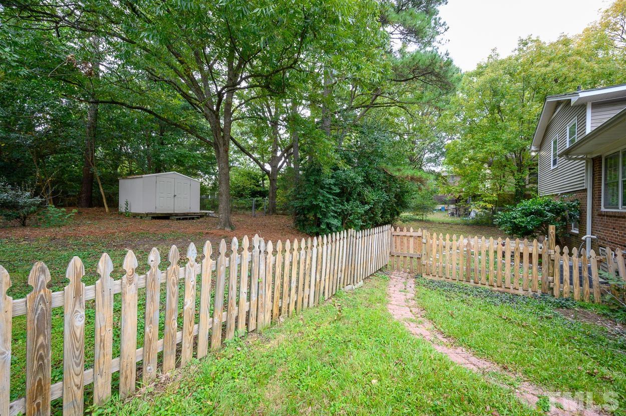 4208 Waterbury Road Raleigh, NC 27604 - Photo 22 of 24 a wooden fence with trees in the background