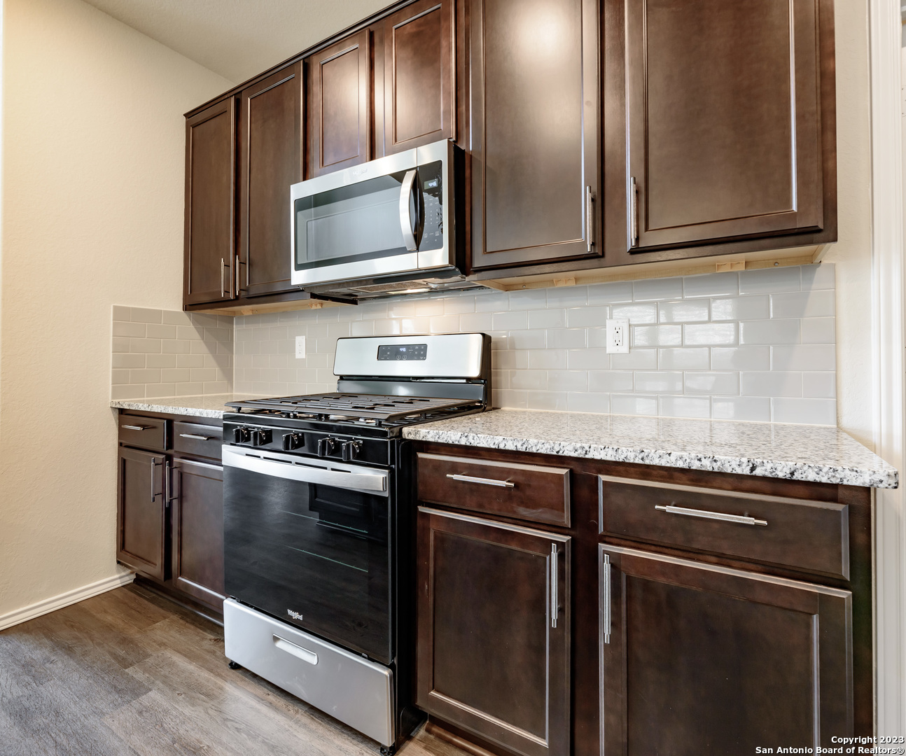 1609 Ranch House New Braunfels, TX 78132 - Photo 9 of 39 a kitchen with stainless steel appliances granite countertop a stove microwave and sink