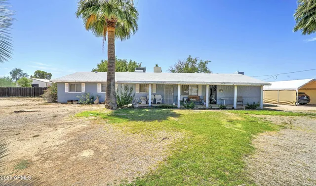 a front view of a house with a yard and potted plants