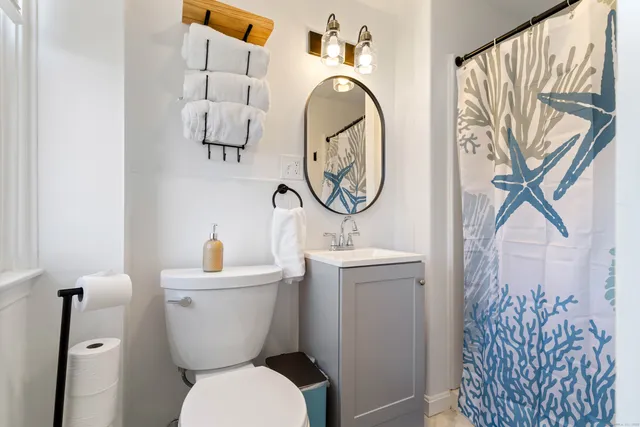 a bathroom with a toilet sink and mirror