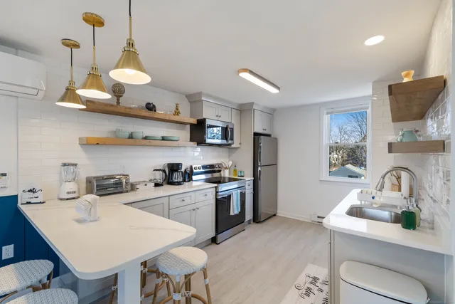 a kitchen with a sink a stove and chairs