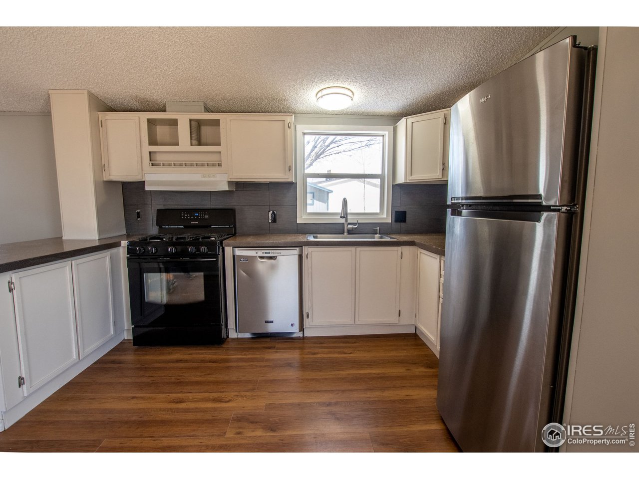 4904 Eagle Crest Boulevard, Unit 221 Firestone, CO 80504 - Photo 5 of 25 a kitchen with granite countertop a refrigerator stove and sink