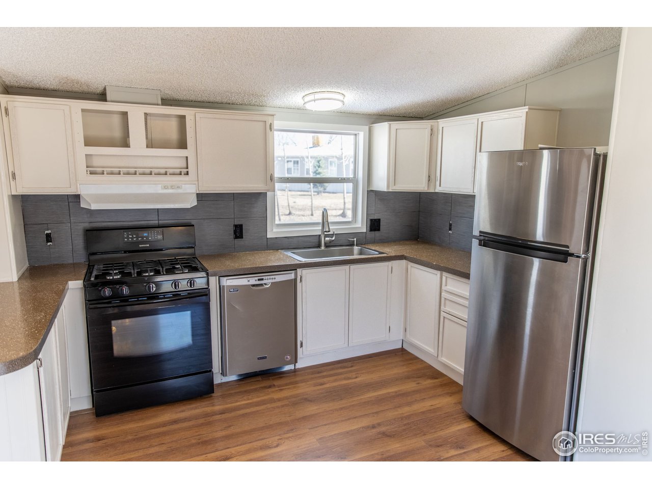 4904 Eagle Crest Boulevard, Unit 221 Firestone, CO 80504 - Photo 6 of 25 a kitchen with a sink stove and refrigerator