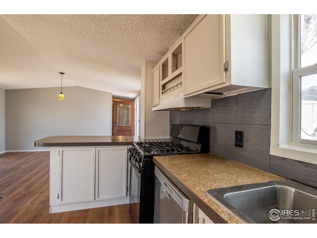 4904 Eagle Crest Boulevard, Unit 221 Firestone, CO 80504 - Photo 7 of 25 a kitchen with a sink a stove and cabinets