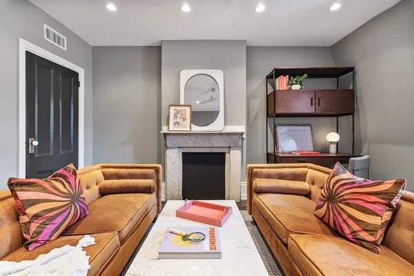 a living room with furniture a flat screen tv and a fireplace