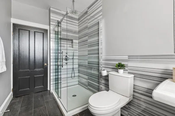 a bathroom with a toilet a sink and shower