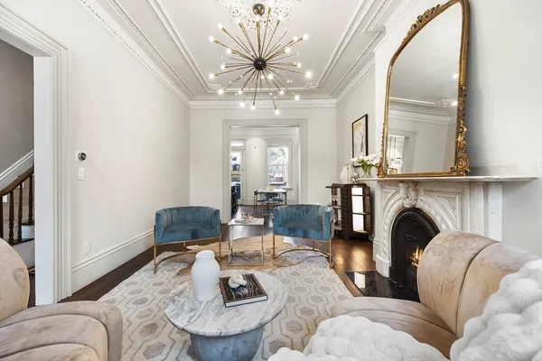 a living room with furniture a fireplace and a chandelier