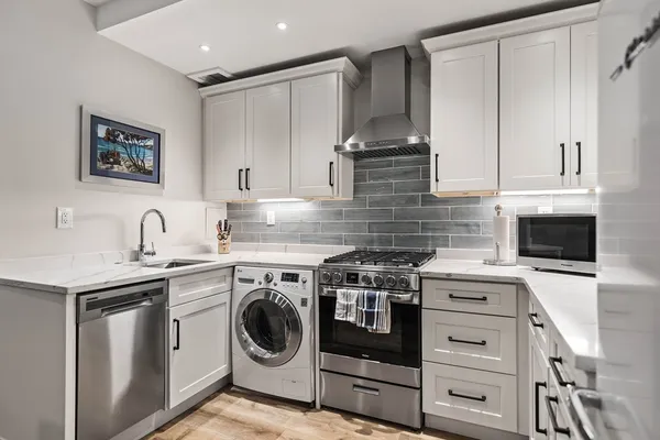 a kitchen with stainless steel appliances granite countertop a stove and a sink
