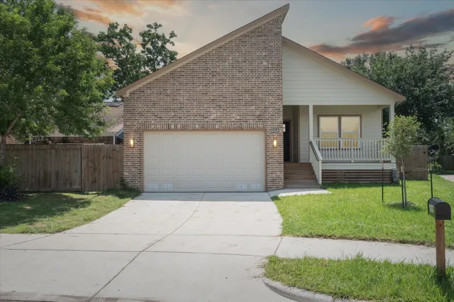 a front view of a house with a yard and trees