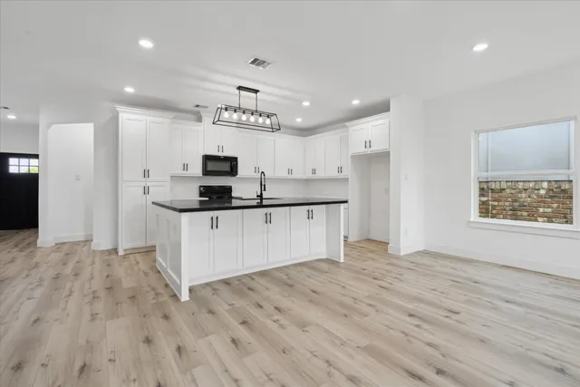 a kitchen with stainless steel appliances a refrigerator sink and white cabinets
