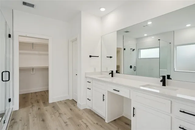 a bathroom with a tub a sink and a large mirror