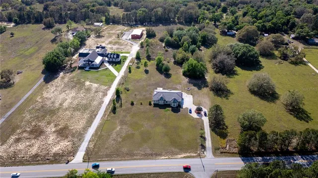 an aerial view of a house with a yard and lake view