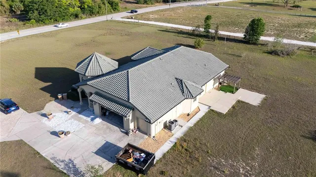 an aerial view of a house with a yard and lake view