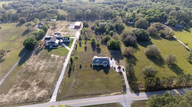 an aerial view of a house with a backyard space and sitting area