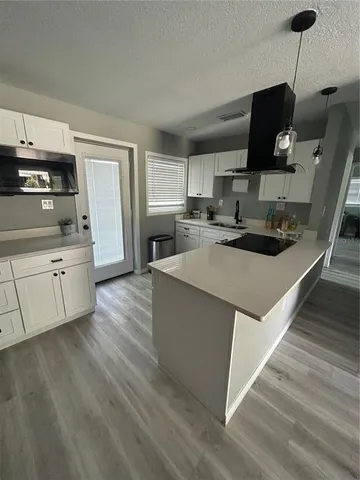 a kitchen with stainless steel appliances a refrigerator a sink a stove a microwave and cabinets