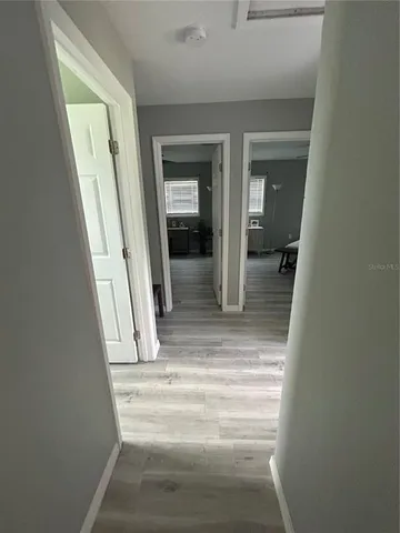 a view of a hallway with wooden floor and staircase