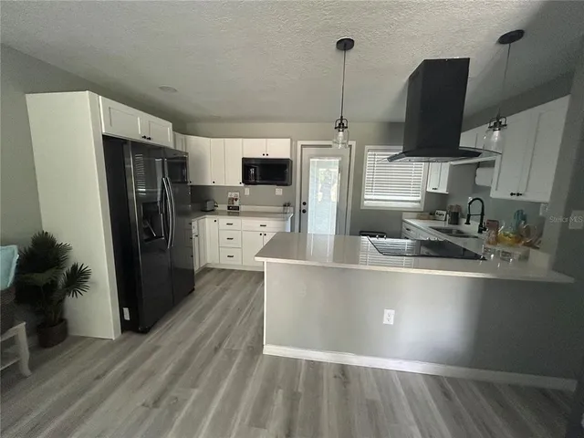 a kitchen with stainless steel appliances granite countertop a sink a stove top oven a counter space and cabinets