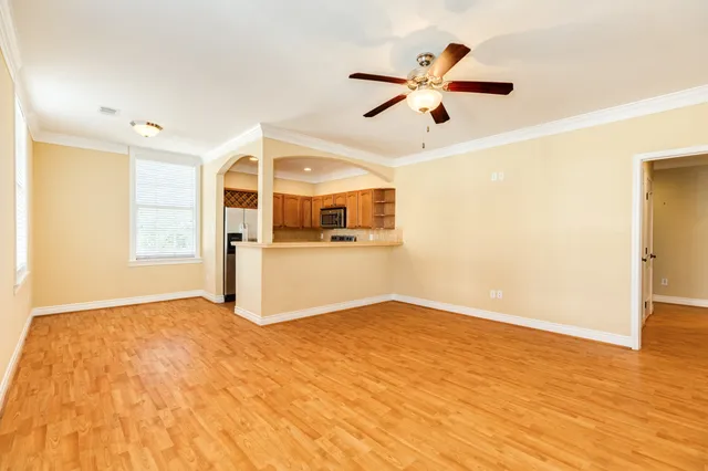 a view of a big room with wooden floor and a ceiling fan