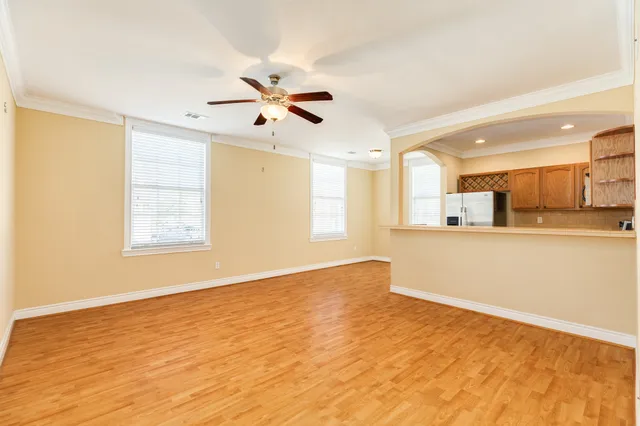 a view of an empty room with window and wooden floor