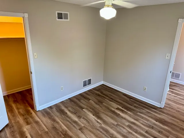 a view of a room with wooden floor and fan