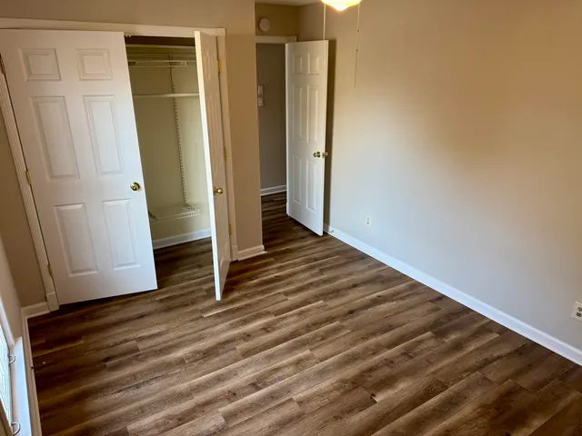 an empty room with wooden floor and entrance