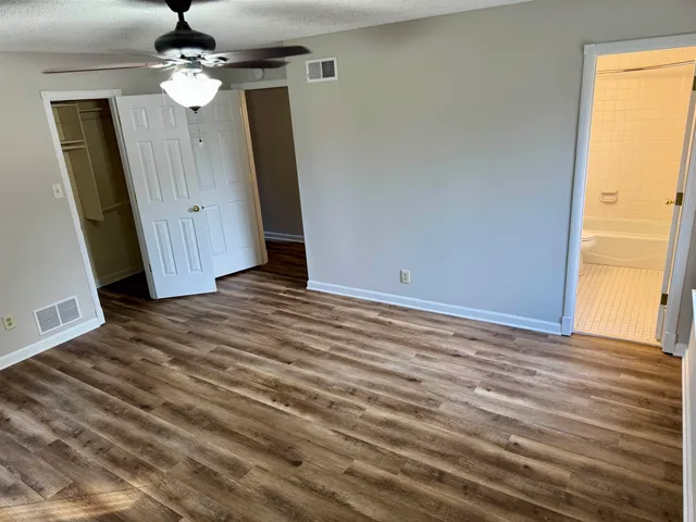 a view of a livingroom with wooden floor and ceiling fan