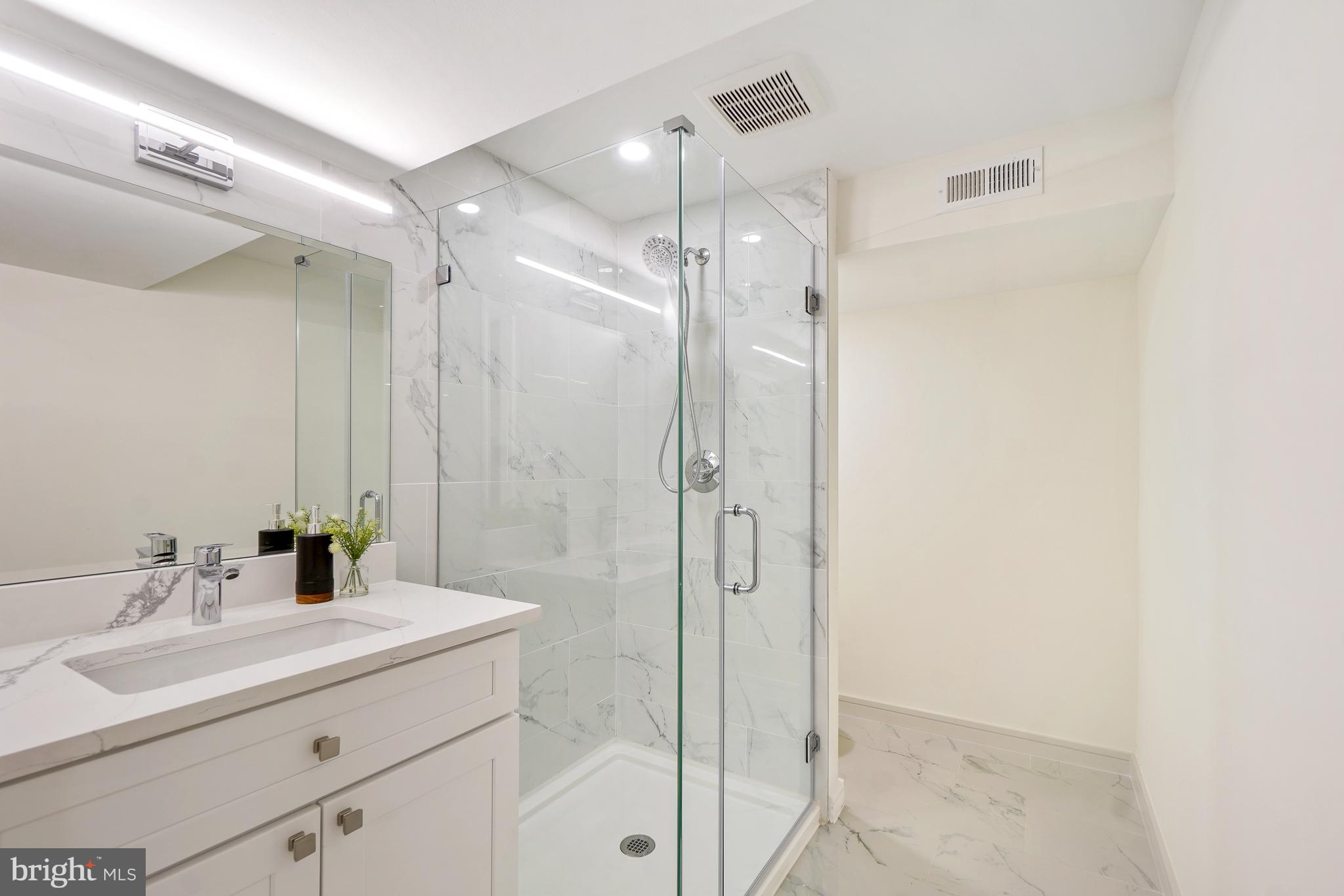 7301 Marbury Road Bethesda, MD 20817 - Photo 67 of 81 a bathroom with a shower sink vanity and mirror