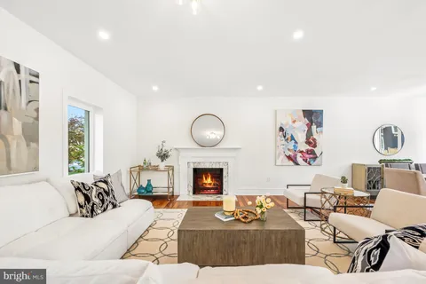 a living room with furniture a large window and a fireplace
