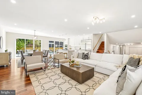 a dining room with furniture a chandelier and wooden floor