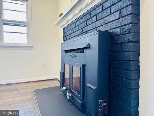 an empty room with wooden floor cabinet and windows