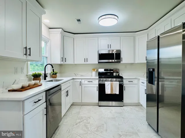 a kitchen with cabinets stainless steel appliances and sink