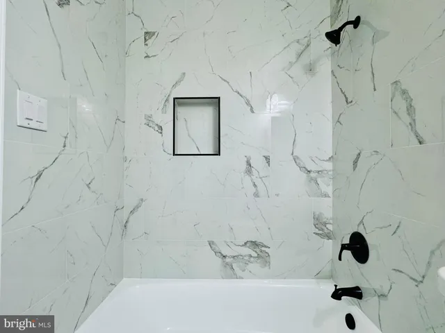 a view of room with walk in closet and wooden floor