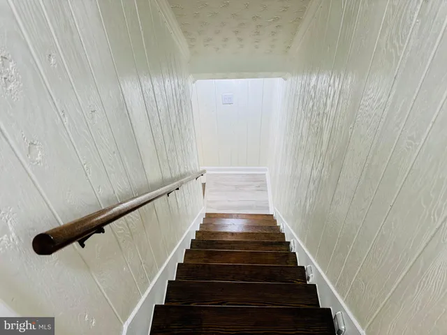a view of a hallway with wooden floor and closet area
