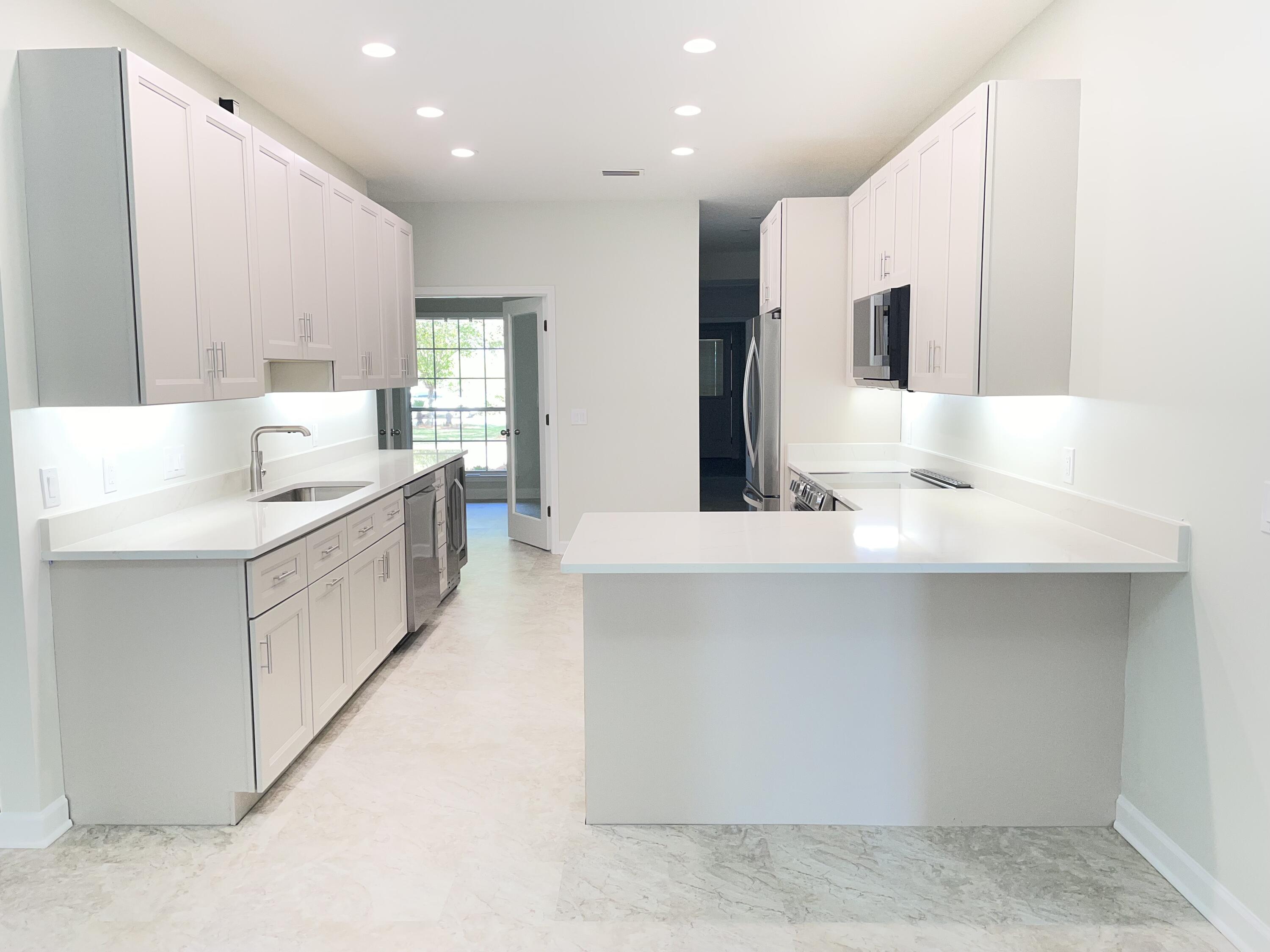 3 Walton Way Miramar Beach, FL 32550 - Photo 10 of 35 a large white kitchen with a large counter top a sink a window and stainless steel appliances