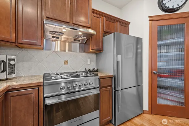 a kitchen with stainless steel appliances granite countertop a refrigerator stove and sink