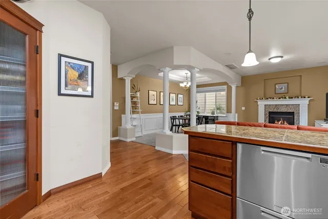 a large kitchen with a sink and dishwasher a stove with wooden floor