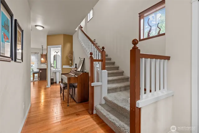 a view of a hallway with wooden floor and staircase