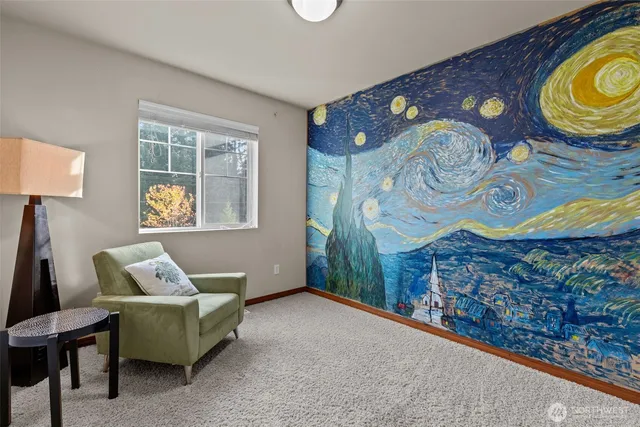 a bedroom with a bed and painting on the wall