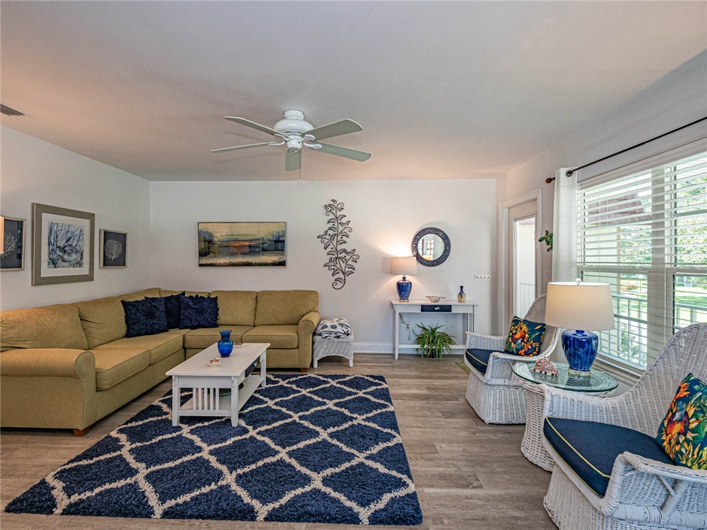 20 Pine Arbor Lane, Unit 202 Vero Beach, FL 32962 - Photo 4 of 36 a living room with furniture wooden floor and a large window