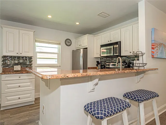 a kitchen with stainless steel appliances granite countertop a stove a sink and a refrigerator