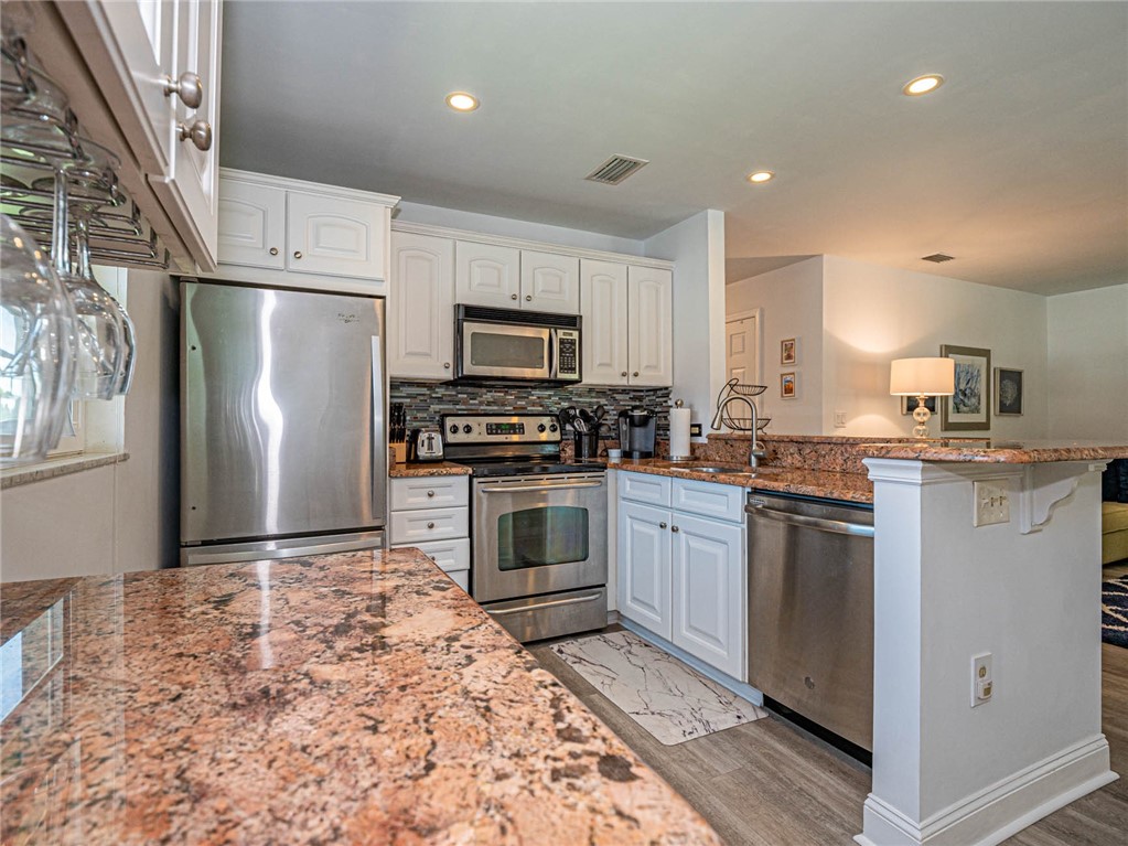 20 Pine Arbor Lane, Unit 202 Vero Beach, FL 32962 - Photo 10 of 36 a kitchen with granite countertop a refrigerator stove and microwave