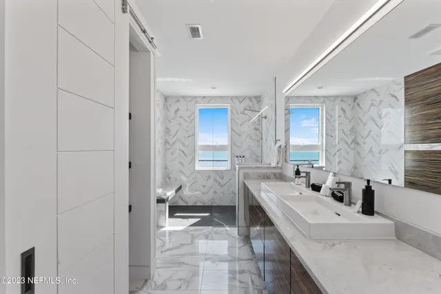 a spacious bathroom with a double vanity sink a mirror and a bathtub