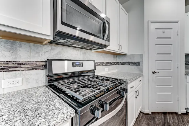 a stove top oven sitting inside of a kitchen