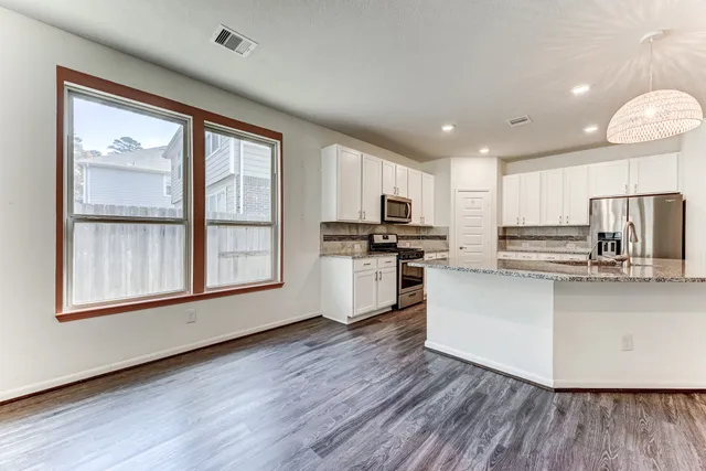 a kitchen with stainless steel appliances a refrigerator sink and cabinets