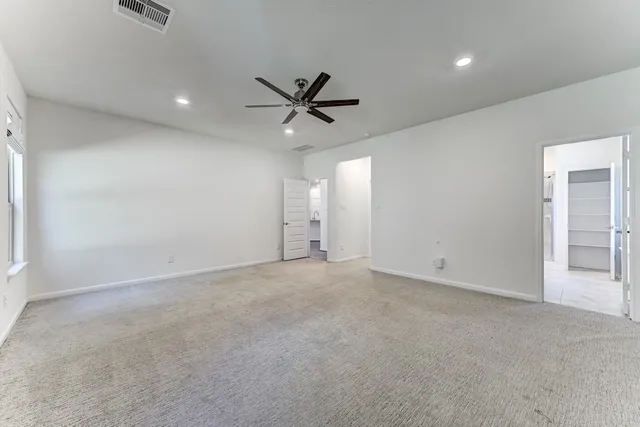 an empty room with fan and windows