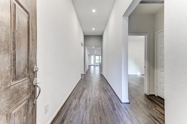 a view of a hallway with wooden floor and staircase