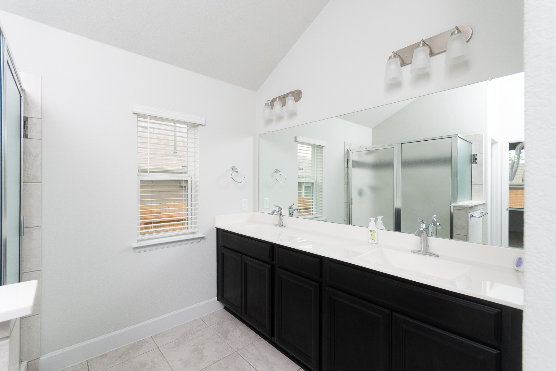 527 Bridgestone Way Buda, TX 78610 - Photo 11 of 21 a bathroom with a double vanity sink a mirror and a bathtub